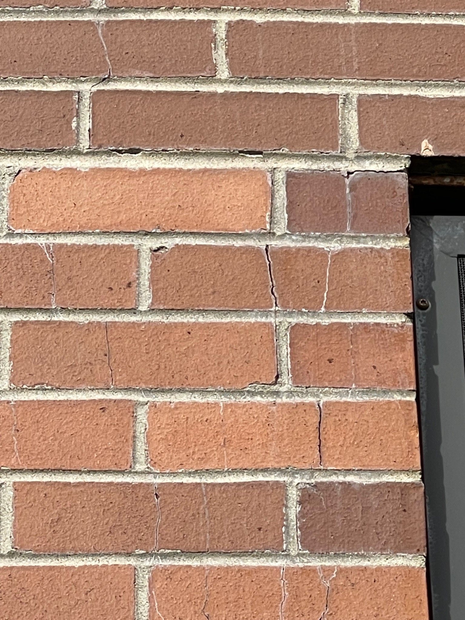 Cracked brick near a window opening at the J David Stewart Armoury showing movement concentrated around an opening