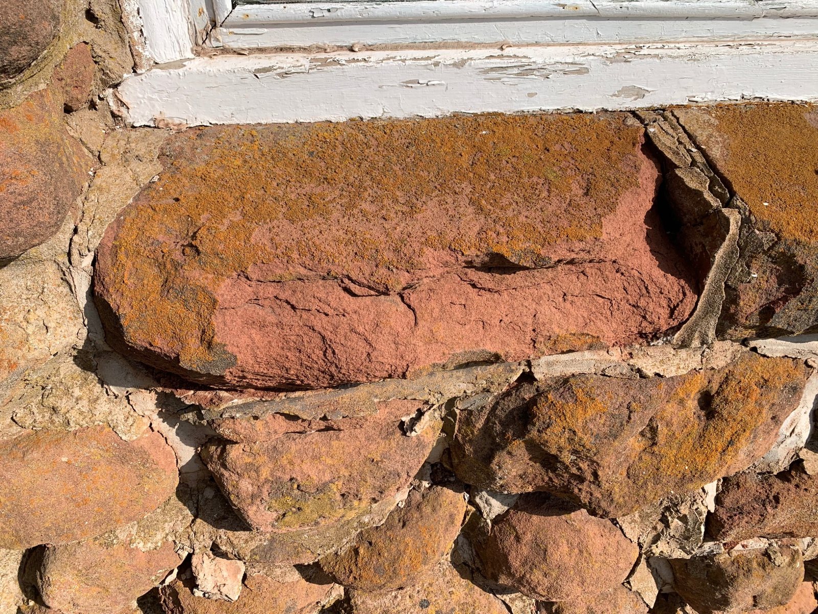 Eroded sandstone below a window at Dalvay by the Sea where water exposure affected the stone