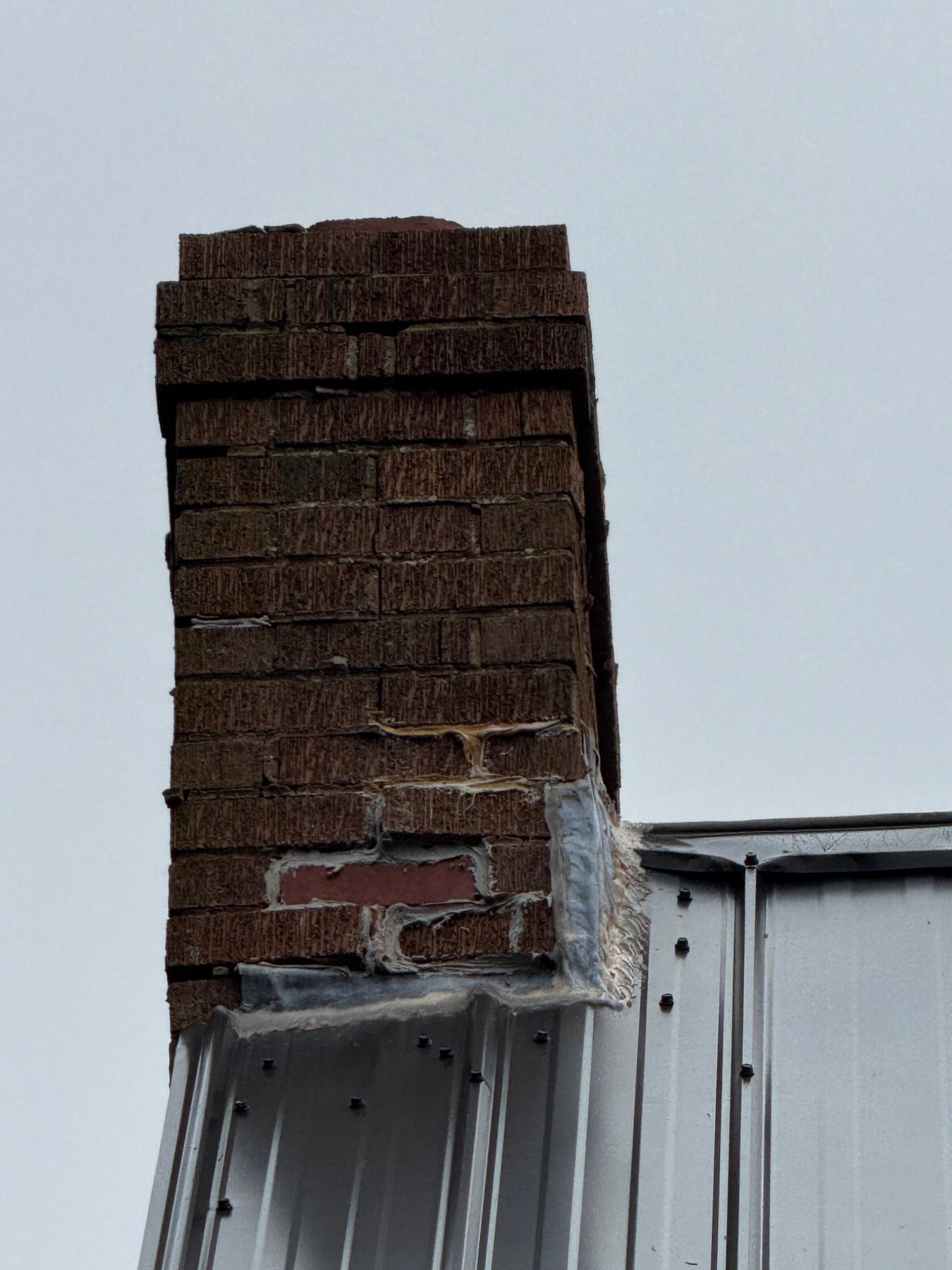 Chimney flashing and roof junction on a masonry chimney