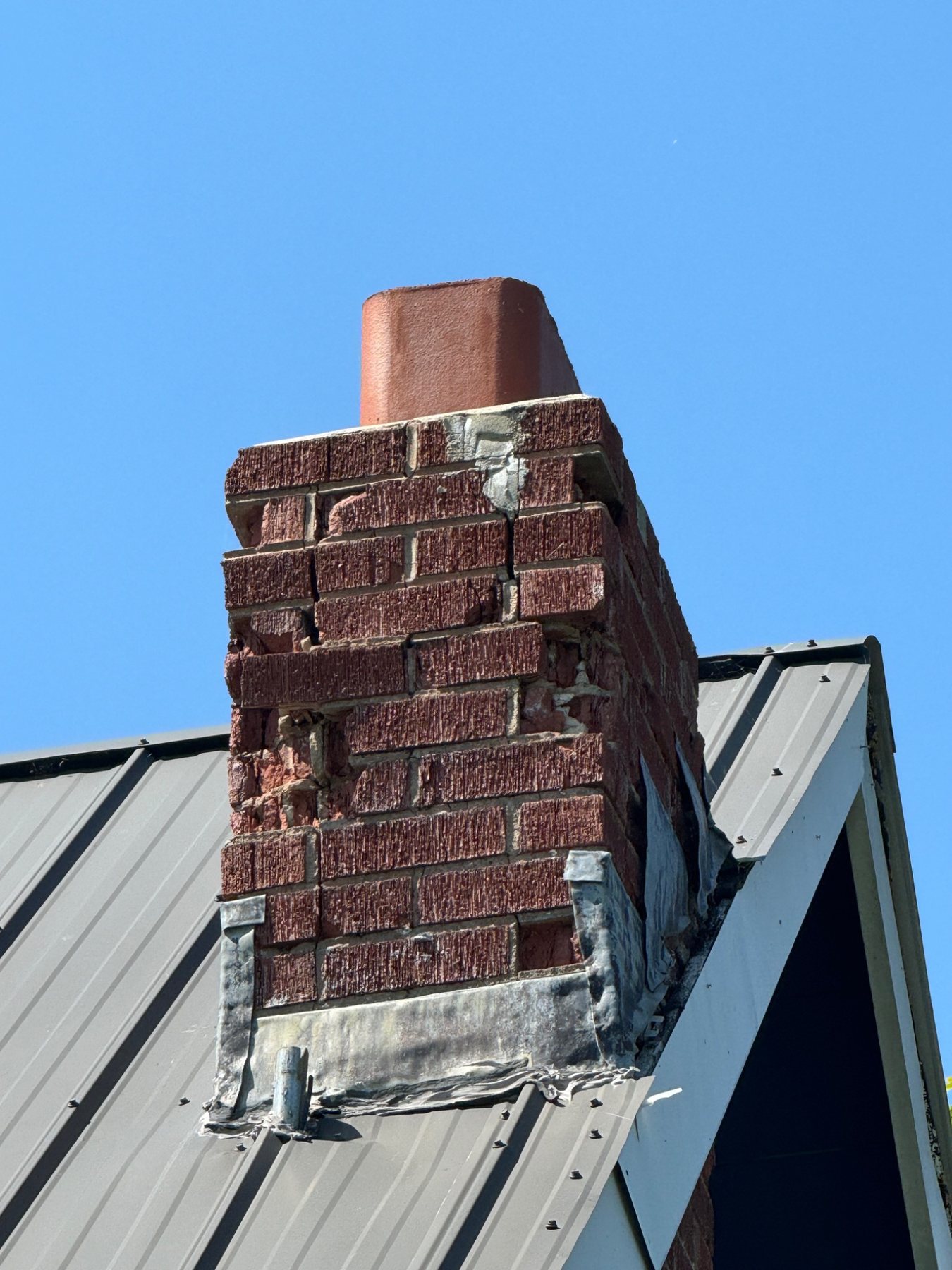 Deteriorated masonry chimney stack affected by moisture and weather exposure