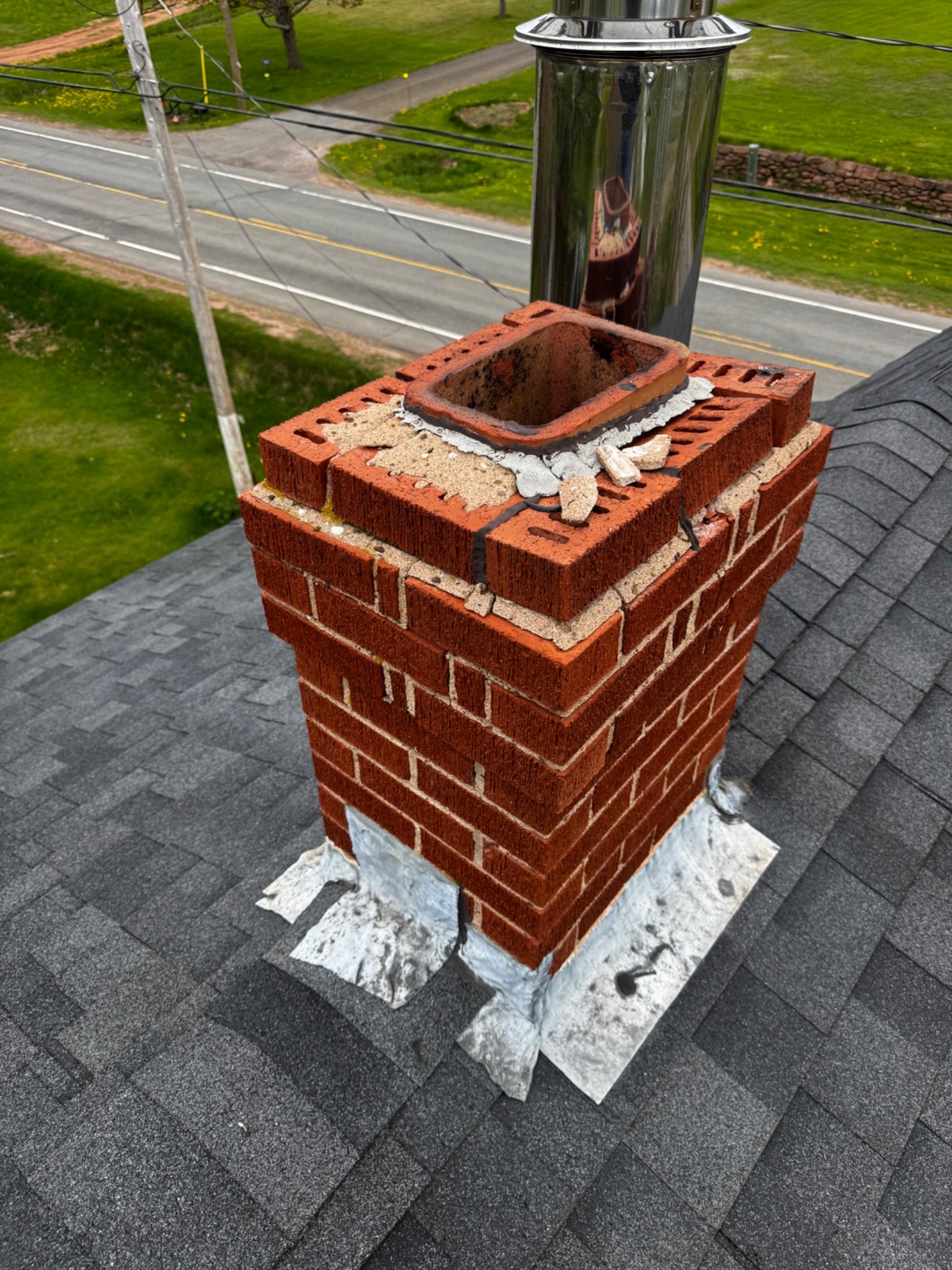 Chimney top under repair showing upper brickwork, flue and roof location