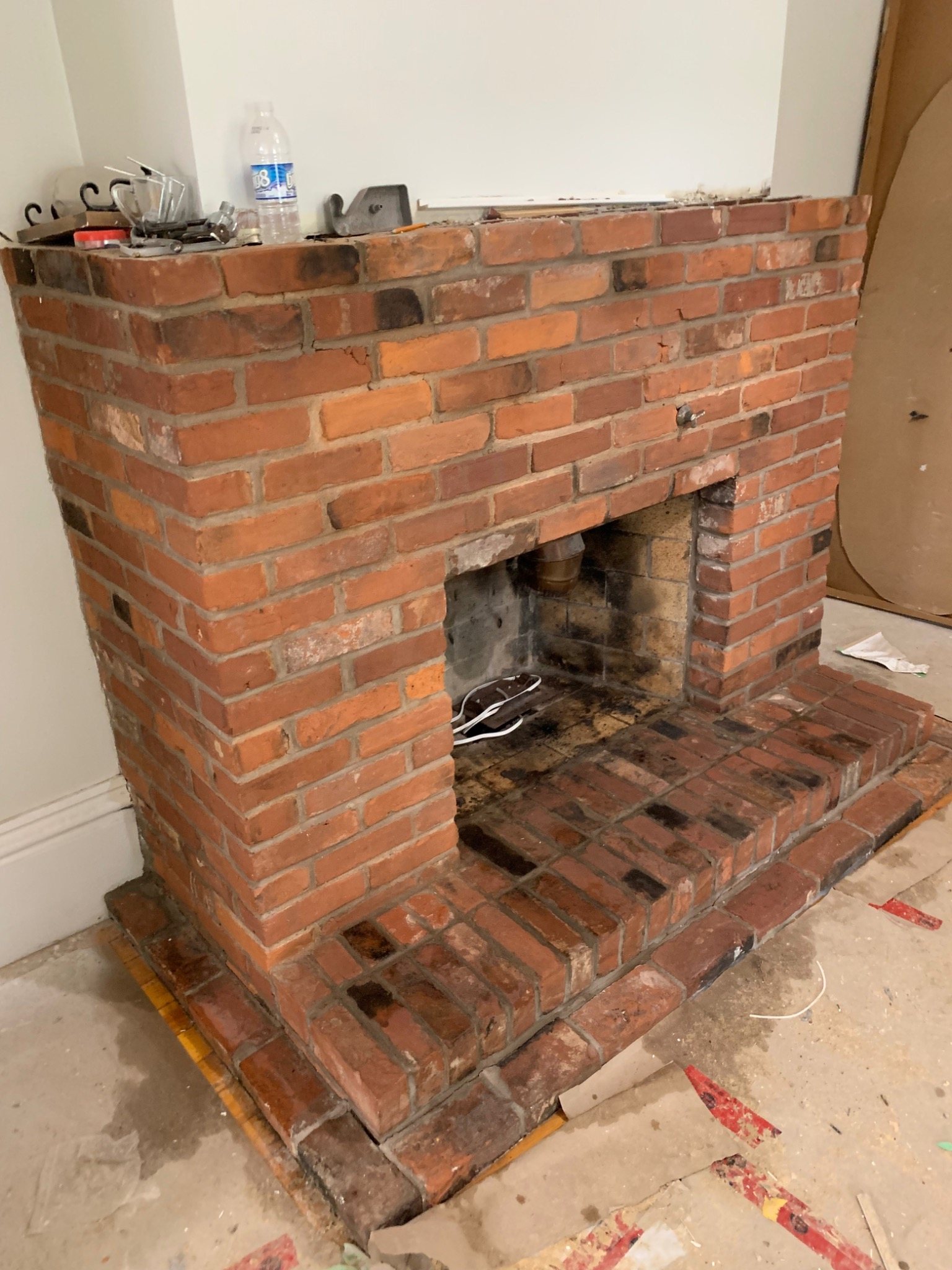 Older brick fireplace during renovation with the masonry face exposed