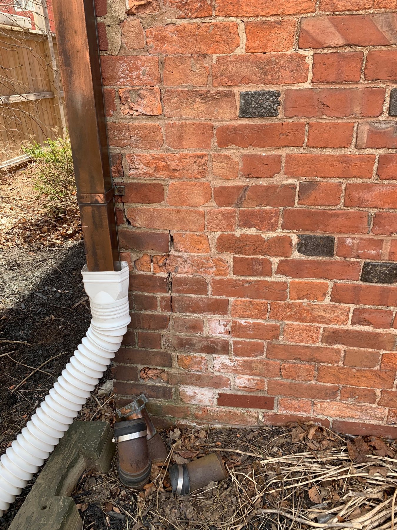 Downspout and masonry wall showing a concentrated exterior water source