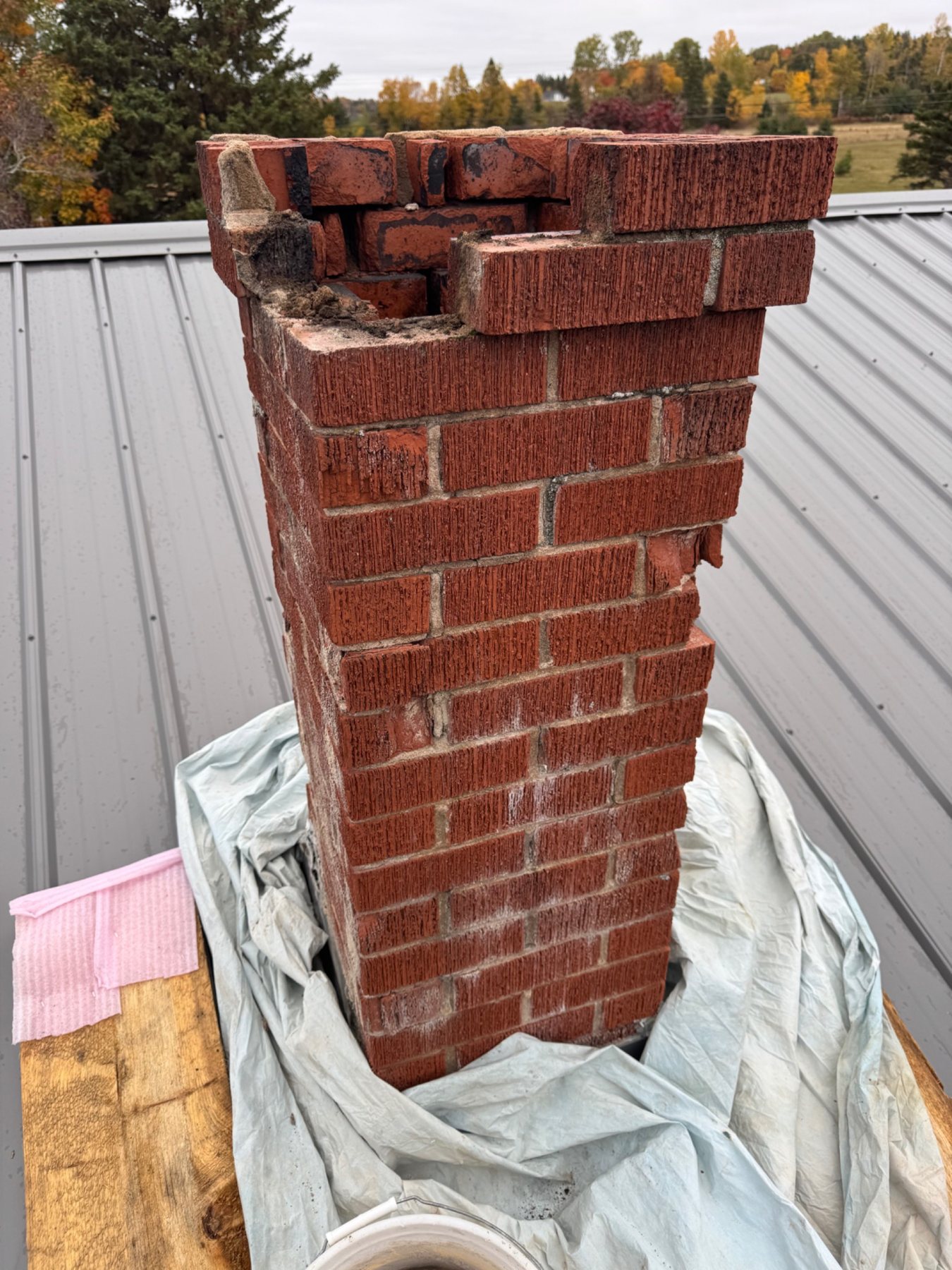 Advanced chimney masonry deterioration with loose and unstable material